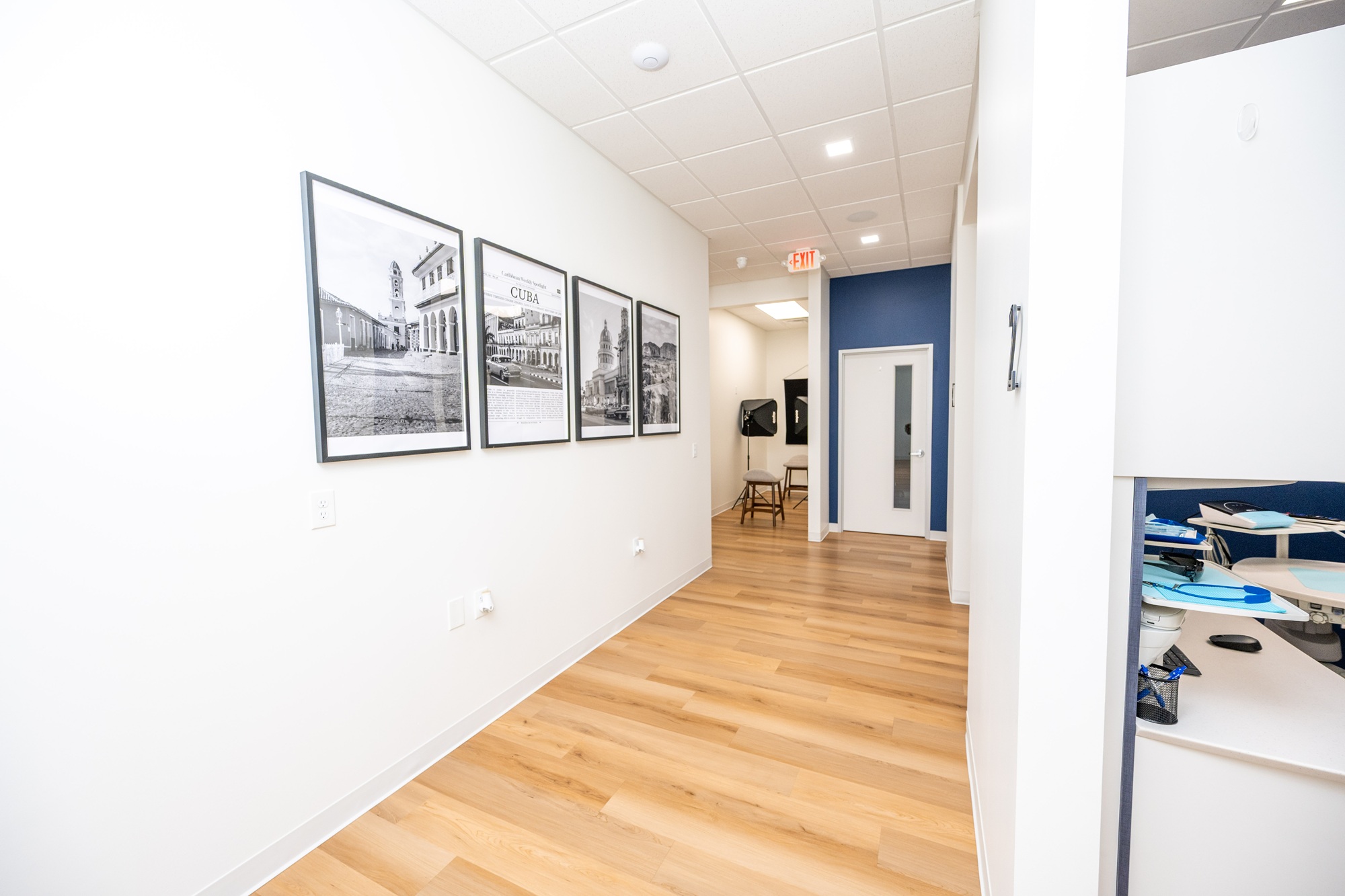 Hallway inside the ProsthDent office in Magnolia, with framed photography of Cuba on the wall